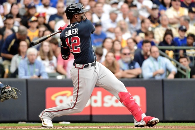 Oct 9, 2021; Milwaukee, Wisconsin, USA; Atlanta Braves right fielder Jorge Soler (12) hits a double against the Milwaukee Brewers during the second inning during game two of the 2021 NLDS at American Family Field. Mandatory Credit: Benny Sieu-USA TODAY Sports