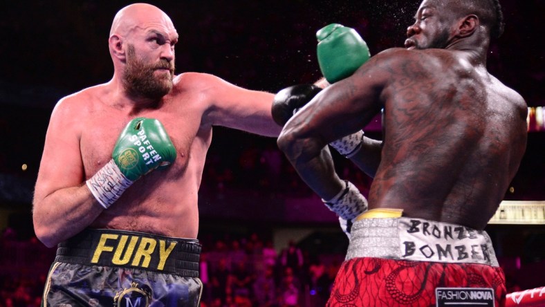 Oct 9, 2021; Las Vegas, Nevada, USA; Deontay Wilder (red/black trunks) and Tyson Fury (black/gold trunks) box during their WBC/Lineal heavyweight championship boxing match at T-Mobile Arena. Mandatory Credit: Joe Camporeale-USA TODAY Sports