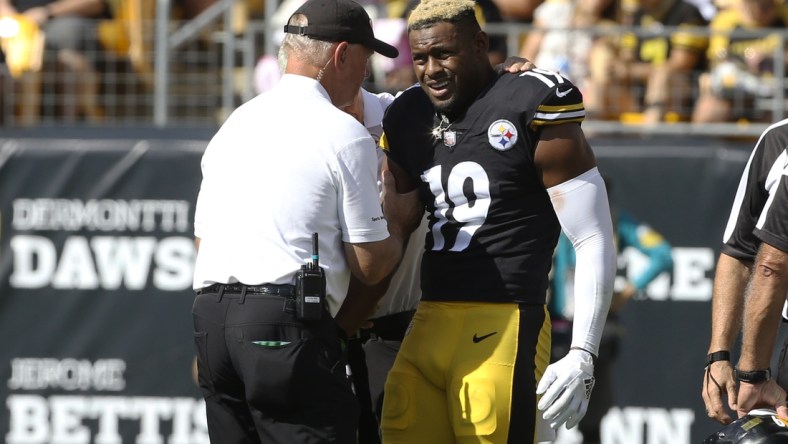 Oct 10, 2021; Pittsburgh, Pennsylvania, USA;  Pittsburgh Steelers team orthopedic doctor James Bradley (left) looks at the right arm of Pittsburgh Steelers wide receiver JuJu Smith-Schuster (19) after Smith-Schuster suffered an apparent injury against the Denver Broncos during the second quarter at Heinz Field. Smith-Schuster  would leave the game. Mandatory Credit: Charles LeClaire-USA TODAY Sports