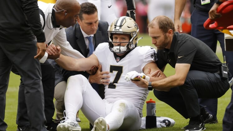 Oct 10, 2021; Landover, Maryland, USA; New Orleans Saints wide receiver Taysom Hill (7) is helped to his feet after being injured against the Washington Football Team during the second quarter at FedExField. Mandatory Credit: Geoff Burke-USA TODAY Sports