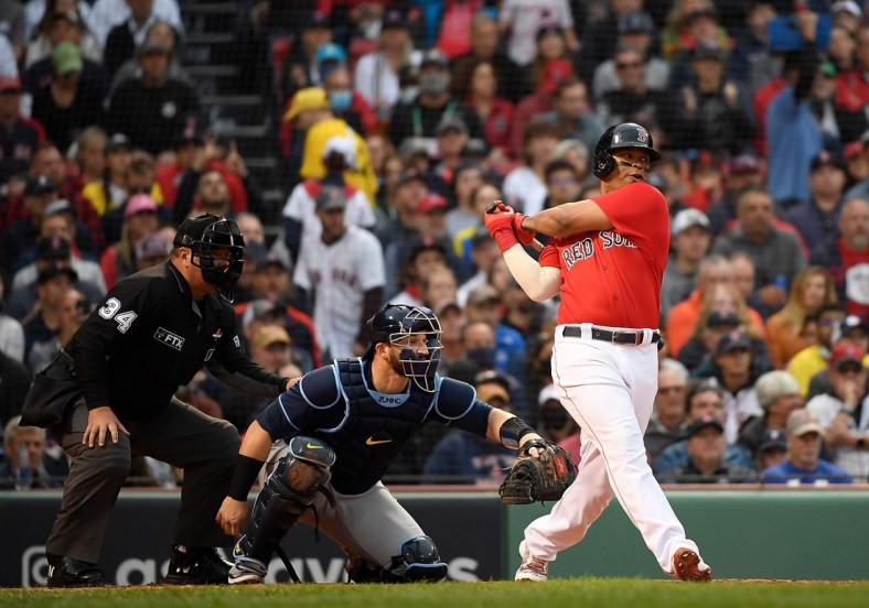 Oct 10, 2021; Boston, Massachusetts, USA; Boston Red Sox third baseman Rafael Devers (11) hits a one run single against the Tampa Bay Rays during the third inning in game three of the 2021 ALDS at Fenway Park. Mandatory Credit: Bob DeChiara-USA TODAY Sports