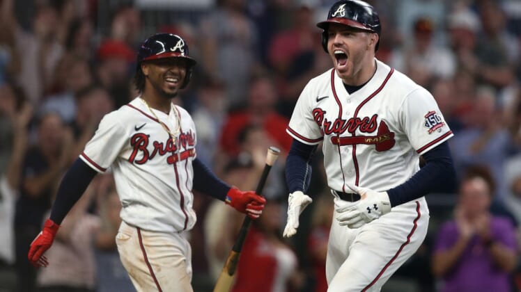 Oct 12, 2021; Cumberland, Georgia, USA; Atlanta Braves first baseman Freddie Freeman (right) celebrates with  second baseman Ozzie Albies (left) after hitting a home run against the Milwaukee Brewers during the eighth inning in game four of the 2021 ALDS at Truist Park. Mandatory Credit: Brett Davis-USA TODAY Sports