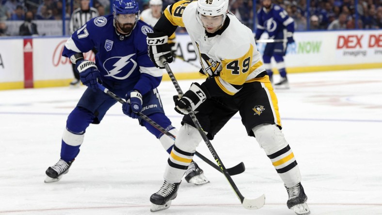 Oct 12, 2021; Tampa, Florida, USA; Pittsburgh Penguins center Dominik Simon (49) skates with the puck against Tampa Bay Lightning left wing Alex Killorn (17) during the third period at Amalie Arena. Mandatory Credit: Kim Klement-USA TODAY Sports