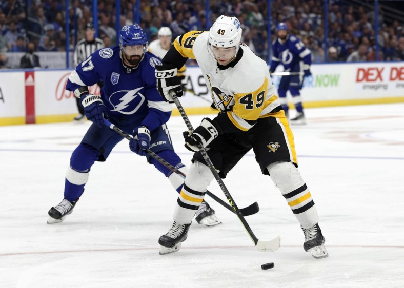 Oct 12, 2021; Tampa, Florida, USA; Pittsburgh Penguins center Dominik Simon (49) skates with the puck against Tampa Bay Lightning left wing Alex Killorn (17) during the third period at Amalie Arena. Mandatory Credit: Kim Klement-USA TODAY Sports