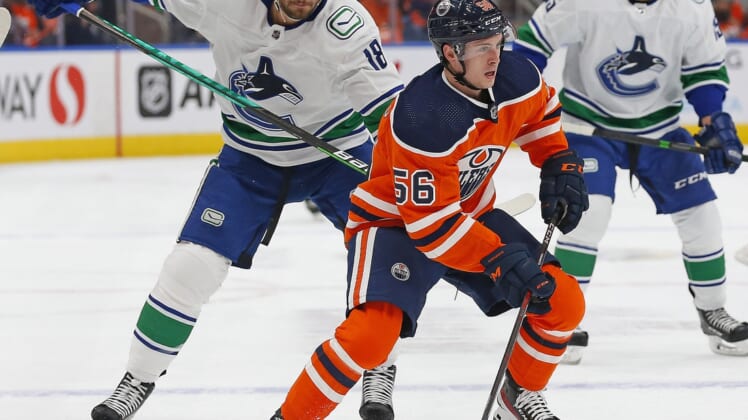Oct 13, 2021; Edmonton, Alberta, CAN; Edmonton Oilers forward Kailer Yamamoto (56) is chased by Vancouver Canucks forward Jason Dickinson (18) during the first period at Rogers Place. Mandatory Credit: Perry Nelson-USA TODAY Sports