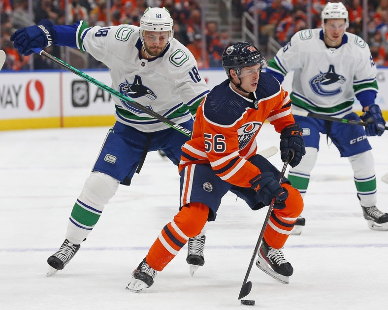 Oct 13, 2021; Edmonton, Alberta, CAN; Edmonton Oilers forward Kailer Yamamoto (56) is chased by Vancouver Canucks forward Jason Dickinson (18) during the first period at Rogers Place. Mandatory Credit: Perry Nelson-USA TODAY Sports