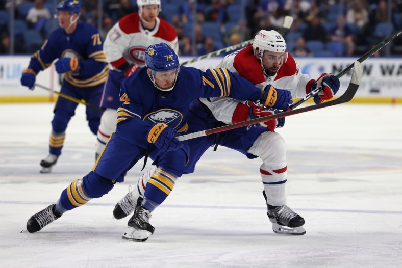 Oct 14, 2021; Buffalo, New York, USA;  Buffalo Sabres right wing Rasmus Asplund (74) and Montreal Canadiens center Cedric Paquette (13) go after a loose puck during the first period at KeyBank Center. Mandatory Credit: Timothy T. Ludwig-USA TODAY Sports