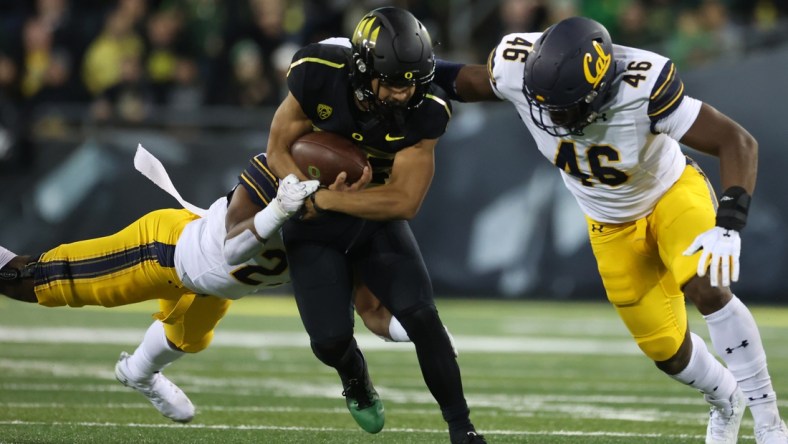 Oct 15, 2021; Eugene, Oregon, USA; Oregon Ducks running back Travis Dye (26) fights for extra yards against California Golden Bears linebacker Marqez Bimage (46) at Autzen Stadium. Mandatory Credit: Jaime Valdez-USA TODAY Sports