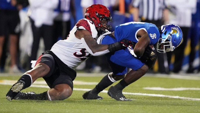 Oct 15, 2021; San Jose, California, USA; San Diego State Aztecs defensive lineman Sefo Mailangi (55) tackles San Jose State Spartans running back Shamar Garrett (24) for a loss during the second quarter at CEFCU Stadium. Mandatory Credit: Darren Yamashita-USA TODAY Sports