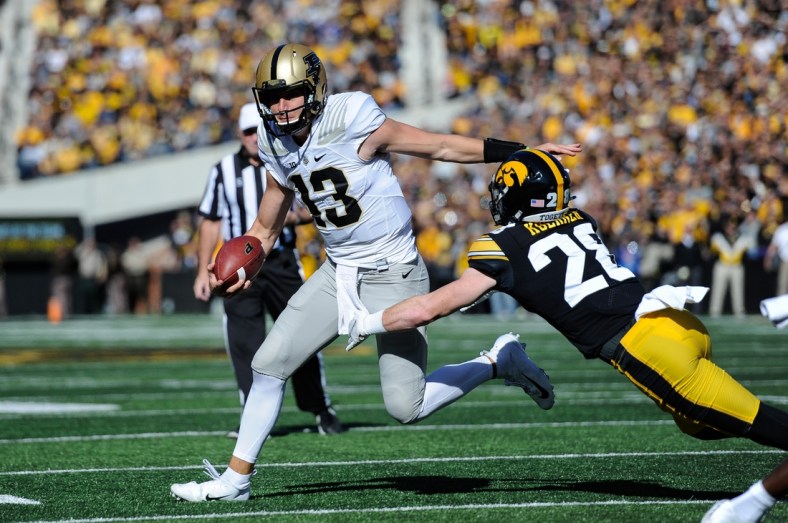 Oct 16, 2021; Iowa City, Iowa, USA; Purdue Boilermakers quarterback Jack Plummer (13) tries to avoid the tackle of Iowa Hawkeyes defensive back Jack Koerner (28) during the first quarter at Kinnick Stadium. Mandatory Credit: Jeffrey Becker-USA TODAY Sports