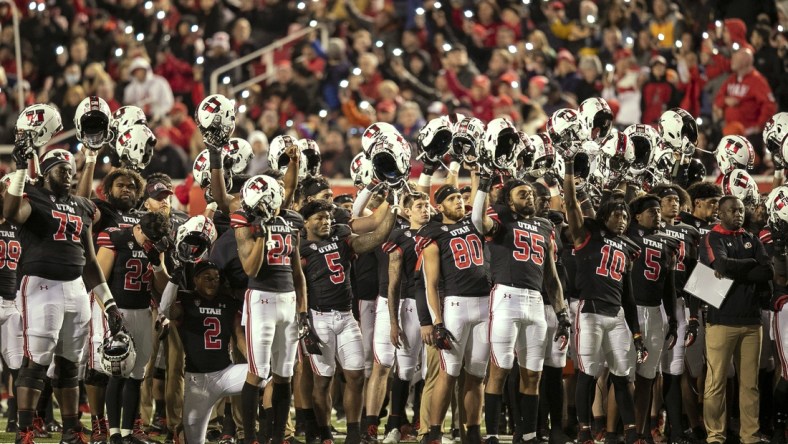 Oct 16, 2021; Salt Lake City, Utah, USA;  Utah Utes players raise their helmets and cheer during the fourth quarter break in a tribute to Aaron Lowe and Ty Jordan in a game against the Arizona State Sun Devils at Rice-Eccles Stadium. Mandatory Credit: Rob Gray-USA TODAY Sports