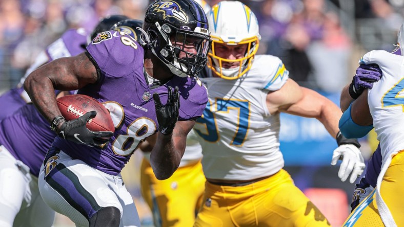 Oct 17, 2021; Baltimore, Maryland, USA; Baltimore Ravens running back Latavius Murray (28) carries the ball as Los Angeles Chargers defensive end Joey Bosa (97) defends during the first half at M&T Bank Stadium. Mandatory Credit: Vincent Carchietta-USA TODAY Sports