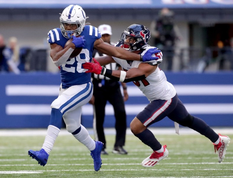 Indianapolis Colts running back Jonathan Taylor (28) pushes off Houston Texans outside linebacker Kamu Grugier-Hill (51) as he rushes the ball Sunday, Oct. 17, 2021, during a game against the Houston Texans at Lucas Oil Stadium in Indianapolis.