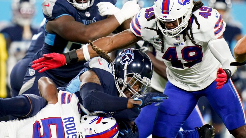 Tennessee Titans running back Derrick Henry (22) is tackled by Buffalo Bills defensive end Greg Rousseau (50) and middle linebacker Tremaine Edmunds (49) at Nissan Stadium Monday, Oct. 18, 2021 in Nashville, Tenn.