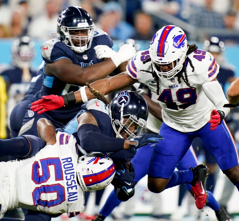 Tennessee Titans running back Derrick Henry (22) is tackled by Buffalo Bills defensive end Greg Rousseau (50) and middle linebacker Tremaine Edmunds (49) at Nissan Stadium Monday, Oct. 18, 2021 in Nashville, Tenn.