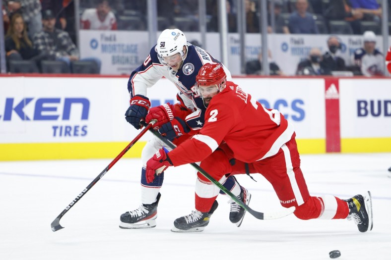 Oct 19, 2021; Detroit, Michigan, USA;  Columbus Blue Jackets left wing Eric Robinson (50) and Detroit Red Wings defenseman Nick Leddy (2) battle for the puck in the first period at Little Caesars Arena. Mandatory Credit: Rick Osentoski-USA TODAY Sports