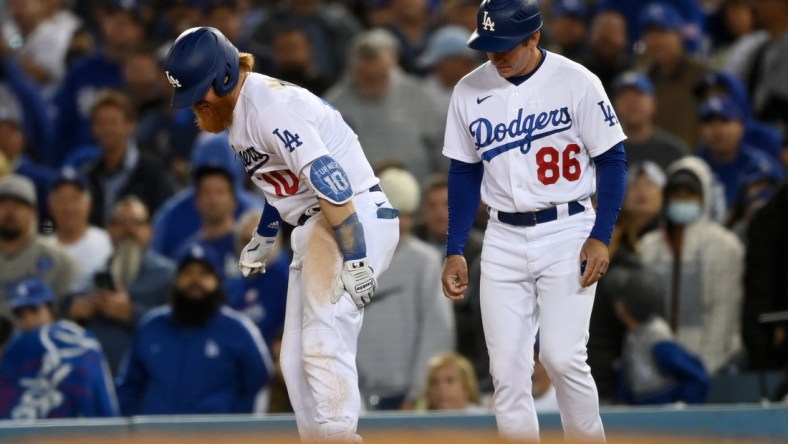 Oct 20, 2021; Los Angeles, California, USA; Los Angeles Dodgers third baseman Justin Turner (10) reacts with first base coach Clayton McCullough (86) after an injury in the seventh inning against the Atlanta Braves during game four of the 2021 NLCS at Dodger Stadium. Mandatory Credit: Jayne Kamin-Oncea-USA TODAY Sports