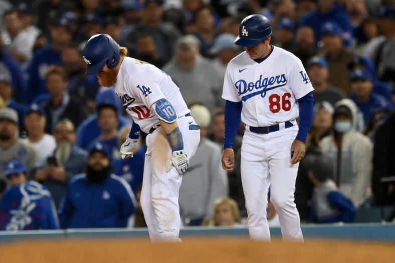 Oct 20, 2021; Los Angeles, California, USA; Los Angeles Dodgers third baseman Justin Turner (10) reacts with first base coach Clayton McCullough (86) after an injury in the seventh inning against the Atlanta Braves during game four of the 2021 NLCS at Dodger Stadium. Mandatory Credit: Jayne Kamin-Oncea-USA TODAY Sports