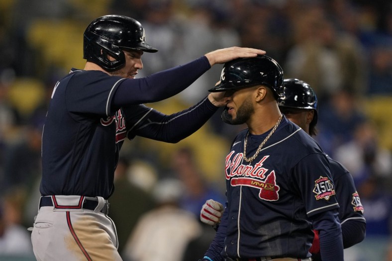 Oct 20, 2021; Los Angeles, California, USA; Atlanta Braves first baseman Freddie Freeman (5) celebrates scoring on a three run home run by left fielder Eddie Rosario (8) in the ninth inning against the Los Angeles Dodgers during game four of the 2021 NLCS at Dodger Stadium. Mandatory Credit: Kirby Lee-USA TODAY Sports