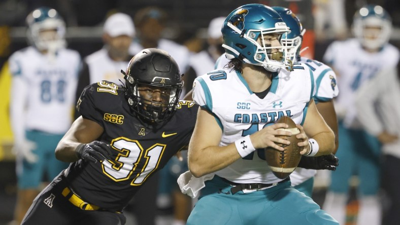 Oct 20, 2021; Boone, North Carolina, USA; Appalachian State Mountaineers linebacker Nick Hampton (31) catches Coastal Carolina Chanticleers quarterback Grayson McCall (10) and sacks him during the second half at Kidd Brewer Stadium. Mandatory Credit: Reinhold Matay-USA TODAY Sports