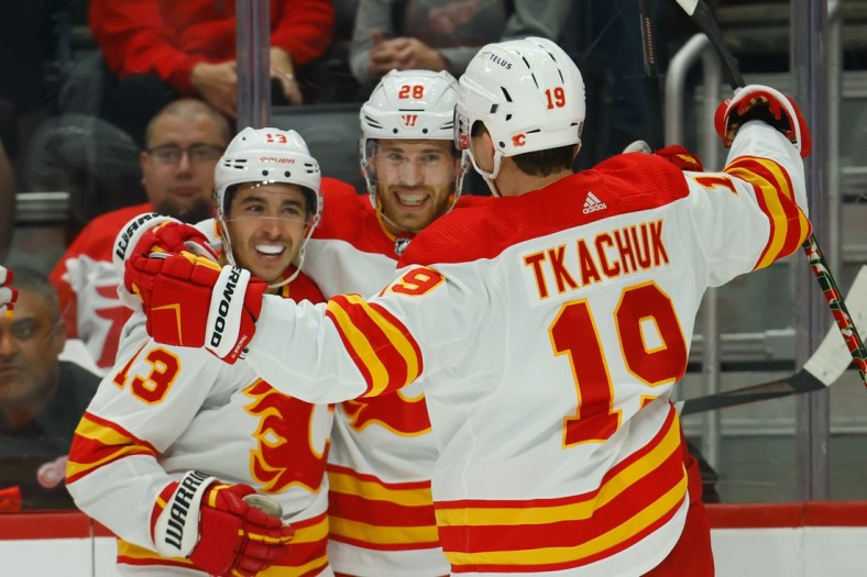 Oct 21, 2021; Detroit, Michigan, USA; Calgary Flames center Elias Lindholm (28) receives congratulations from teammates after scoring in the first period against the Detroit Red Wings at Little Caesars Arena. Mandatory Credit: Rick Osentoski-USA TODAY Sports
