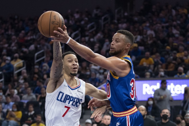 October 21, 2021; San Francisco, California, USA; Golden State Warriors guard Stephen Curry (30) passes the basketball against LA Clippers guard Amir Coffey (7) during the second quarter at Chase Center. Mandatory Credit: Kyle Terada-USA TODAY Sports