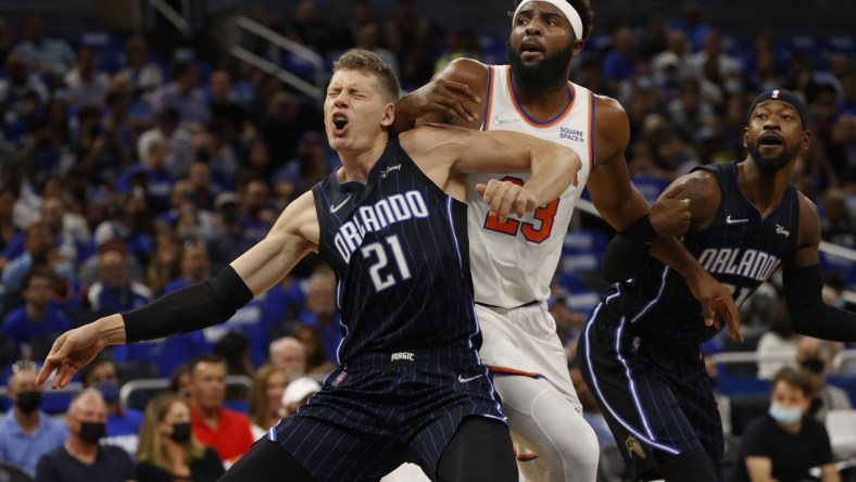 Oct 22, 2021; Orlando, Florida, USA; Orlando Magic center Moritz Wagner (21) and New York Knicks center Mitchell Robinson (23) defend to go after the ball during the first quarter at Amway Center. Mandatory Credit: Kim Klement-USA TODAY Sports