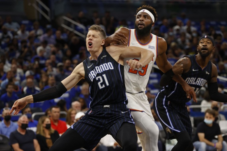 Oct 22, 2021; Orlando, Florida, USA; Orlando Magic center Moritz Wagner (21) and New York Knicks center Mitchell Robinson (23) defend to go after the ball during the first quarter at Amway Center. Mandatory Credit: Kim Klement-USA TODAY Sports