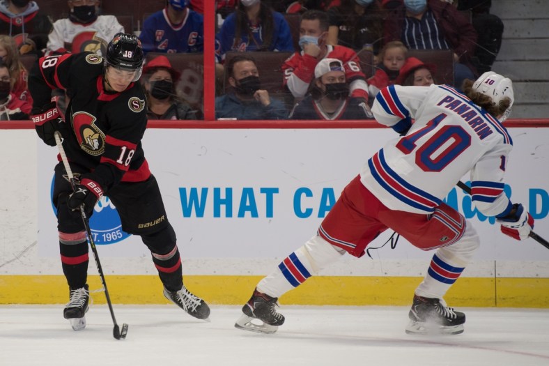 Oct 23, 2021; Ottawa, Ontario, CAN; Ottawa Senators left wing Tim St tzle (18) skates with the puck away from New York Rangers left wing Artemi Panarin (10) in the first period at the Canadian Tire Centre. Mandatory Credit: Marc DesRosiers-USA TODAY Sports