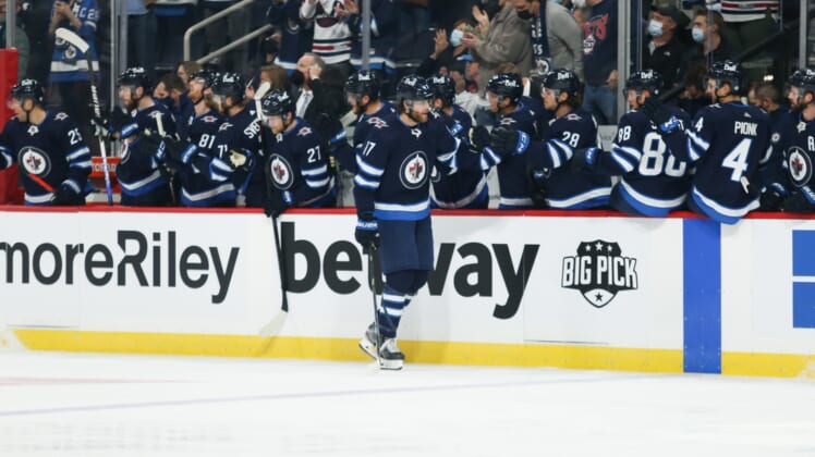 Oct 23, 2021; Winnipeg, Manitoba, CAN;  Winnipeg Jets forward Adam Lowry (17) is congratulated by his team mates on his goal against the Nashville Predators during the first period at Canada Life Centre. Mandatory Credit: Terrence Lee-USA TODAY Sports