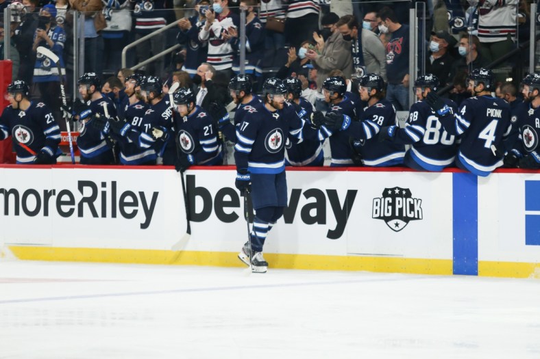 Oct 23, 2021; Winnipeg, Manitoba, CAN;  Winnipeg Jets forward Adam Lowry (17) is congratulated by his team mates on his goal against the Nashville Predators during the first period at Canada Life Centre. Mandatory Credit: Terrence Lee-USA TODAY Sports