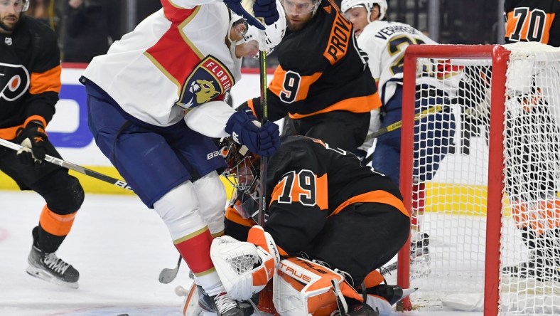 Oct 23, 2021; Philadelphia, Pennsylvania, USA;  Philadelphia Flyers goaltender Carter Hart (79) and  defenseman Ivan Provorov (9) hold off Florida Panthers center Eetu Luostarinen (27) during the second period at Wells Fargo Center. Mandatory Credit: Eric Hartline-USA TODAY Sports