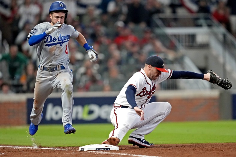 Oct 23, 2021; Cumberland, Georgia, USA; Atlanta Braves first baseman Freddie Freeman (5) makes a catch to force out Los Angeles Dodgers second baseman Trea Turner (6) during the sixth inning in game six of the 2021 NLCS at Truist Park. Mandatory Credit: Dale Zanine-USA TODAY Sports