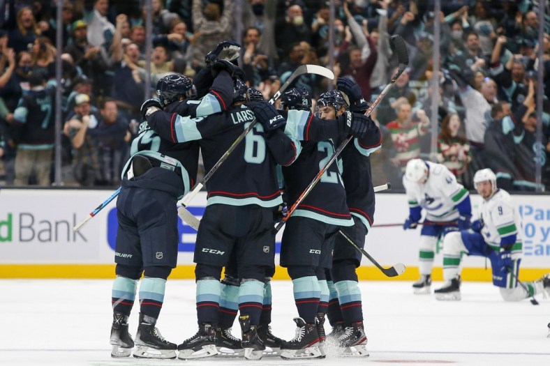 Oct 23, 2021; Seattle, Washington, USA; Seattle Kraken defenseman Vince Dunn (29) celebrates with teammates after scoring a goal against the Vancouver Canucks during the first period at Climate Pledge Arena. Mandatory Credit: Joe Nicholson-USA TODAY Sports