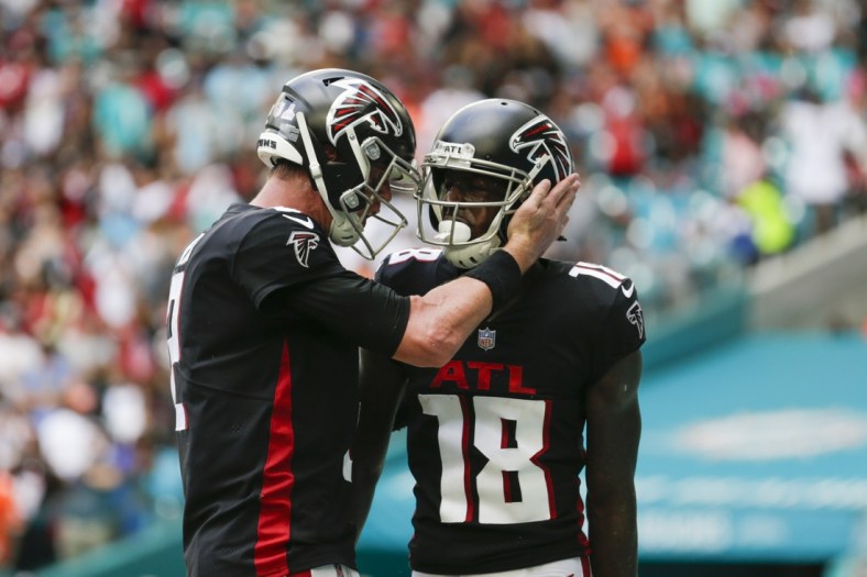 Oct 24, 2021; Miami Gardens, Florida, USA; Atlanta Falcons wide receiver Calvin Ridley (18) gets a tap on the helmet from quarterback Matt Ryan (2) after scoring a touchdown against the Miami Dolphins during the second quarter of the game at Hard Rock Stadium. Mandatory Credit: Sam Navarro-USA TODAY Sports