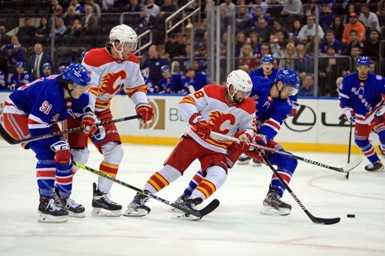 Oct 25, 2021; New York, New York, USA; Calgary Flames defenseman Oliver Kylington (58) and New York Rangers center Filip Chytil (72) fight for the puck during the first period at Madison Square Garden. Mandatory Credit: Danny Wild-USA TODAY Sports