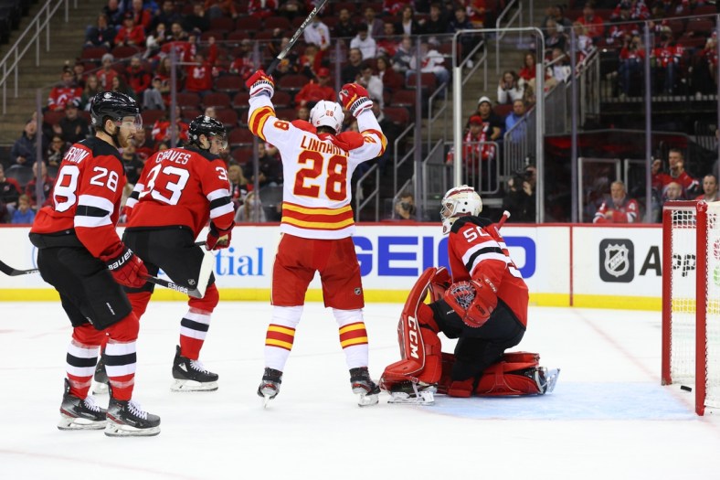 Oct 26, 2021; Newark, New Jersey, USA; Calgary Flames center Elias Lindholm (28) celebrates his goal on New Jersey Devils goaltender Nico Daws (50) during the first period at Prudential Center. Mandatory Credit: Ed Mulholland-USA TODAY Sports