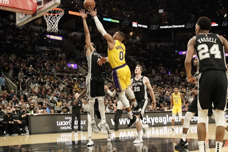 Oct 26, 2021; San Antonio, Texas, USA; Los Angeles Lakers guard Russell Westbrook (0) lays in a basket over guard Derrick White (4) in the second half of the game against the San Antonio Spurs at AT&T Center. Mandatory Credit: Scott Wachter-USA TODAY Sports