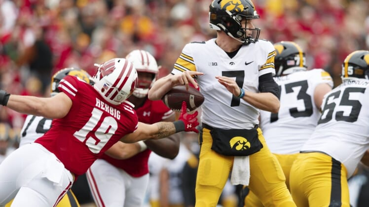 Oct 30, 2021; Madison, Wisconsin, USA;  Wisconsin Badgers linebacker Nick Herbig (19) strips the ball away from Iowa Hawkeyes quarterback Spencer Petras (7) during the second quarter at Camp Randall Stadium. Mandatory Credit: Jeff Hanisch-USA TODAY Sports