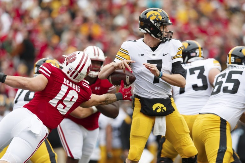 Oct 30, 2021; Madison, Wisconsin, USA;  Wisconsin Badgers linebacker Nick Herbig (19) strips the ball away from Iowa Hawkeyes quarterback Spencer Petras (7) during the second quarter at Camp Randall Stadium. Mandatory Credit: Jeff Hanisch-USA TODAY Sports