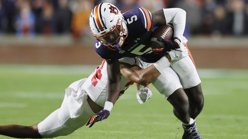 Oct 30, 2021; Auburn, Alabama, USA; Auburn Tigers wide receiver Kobe Hudson (5) is tackled by Mississippi Rebels defensive back Deane Leonard (24) during the first quarter at Jordan-Hare Stadium.  Mandatory Credit: John Reed-USA TODAY Sports