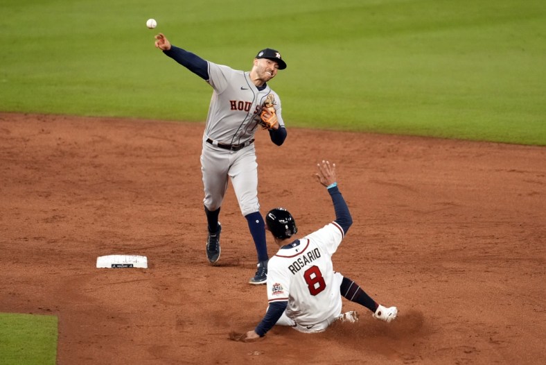 Oct 30, 2021; Atlanta, Georgia, USA; Houston Astros shortstop Carlos Correa (1) turns a double play over Atlanta Braves left fielder Eddie Rosario (8) to end the third inning of game four of the 2021 World Series at Truist Park. Mandatory Credit: Dale Zanine-USA TODAY Sports