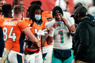 Sep 12, 2021; Foxborough, Massachusetts, USA; Miami Dolphins head coach Brian Flores talks with quarterback Tua Tagovailoa (1) during a timeout during the second half of a game against the New England Patriots at Gillette Stadium. Mandatory Credit: Brian Fluharty-USA TODAY Sports