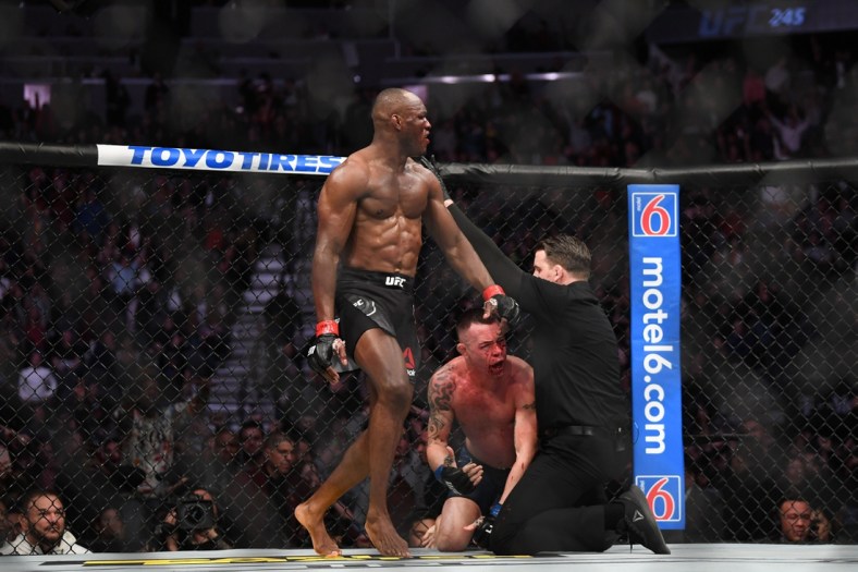 Dec 14, 2019; Las Vegas, NV, USA; (Editor's Note: Graphic Content) Kamaru Usman (red gloves) reacts as referee Marc Goddard stops his bout against Colby Covington (blue gloves) during UFC 245 at T-Mobile Arena. Mandatory Credit: Stephen R. Sylvanie-USA TODAY Sports