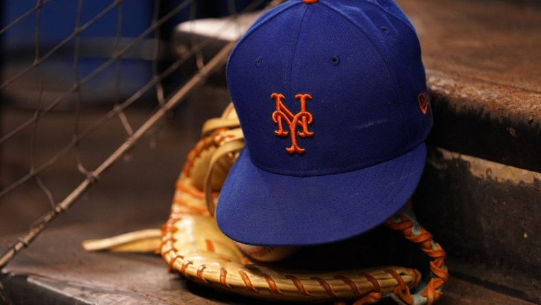 Aug 5, 2021; Miami, Florida, USA; A detailed view of the cap and mitt of New York Mets first baseman Pete Alonso (not pictured) on the dugout steps prior the the game against the Miami Marlins at loanDepot park. Mandatory Credit: Jasen Vinlove-USA TODAY Sports