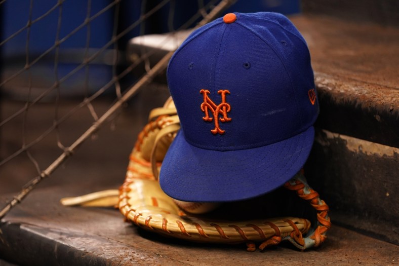 Aug 5, 2021; Miami, Florida, USA; A detailed view of the cap and mitt of New York Mets first baseman Pete Alonso (not pictured) on the dugout steps prior the the game against the Miami Marlins at loanDepot park. Mandatory Credit: Jasen Vinlove-USA TODAY Sports