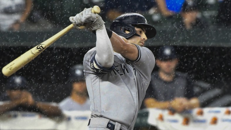 Sep 16, 2021; Baltimore, Maryland, USA; New York Yankees shortstop Tyler Wade (14) swings as rain comes down during the sixth inning against the Baltimore Orioles  at Oriole Park at Camden Yards. Mandatory Credit: Tommy Gilligan-USA TODAY Sports