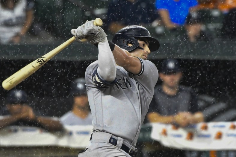 Sep 16, 2021; Baltimore, Maryland, USA; New York Yankees shortstop Tyler Wade (14) swings as rain comes down during the sixth inning against the Baltimore Orioles  at Oriole Park at Camden Yards. Mandatory Credit: Tommy Gilligan-USA TODAY Sports