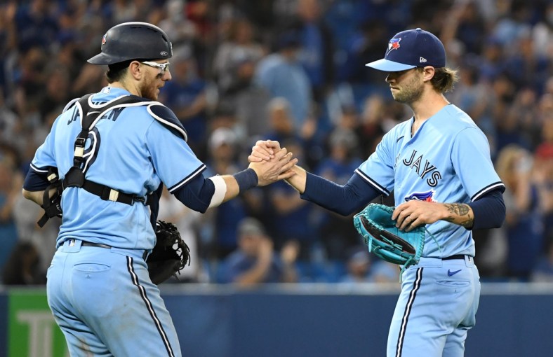 Oct 3, 2021; Toronto, Ontario, CAN; Toronto Blue Jays relief pitcher Adam Cimber (90) shakes hands with catcher Danny Jansen (9) after defeating the Baltimore Orioles at Rogers Centre. Mandatory Credit: Dan Hamilton-USA TODAY Sports