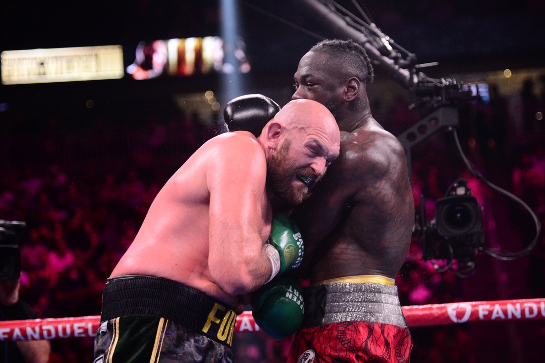 Oct 9, 2021; Las Vegas, Nevada, USA; Deontay Wilder (red/black trunks) and Tyson Fury (black/gold trunks) box during their WBC/Lineal heavyweight championship boxing match at T-Mobile Arena. Mandatory Credit: Joe Camporeale-USA TODAY Sports